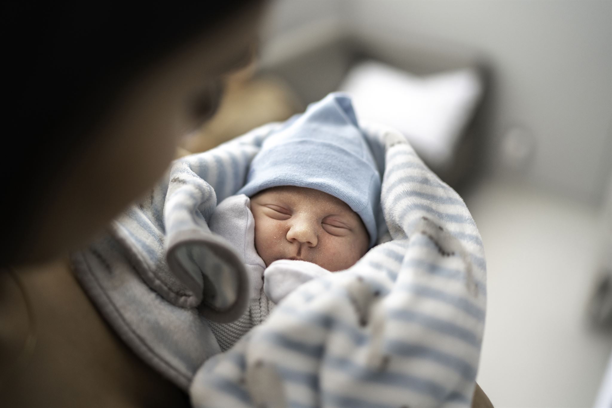 Person holding baby wrapped in blanket